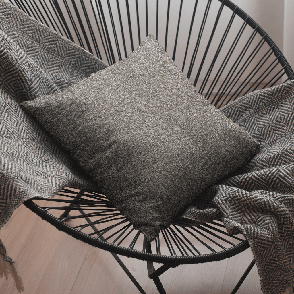 Coussin effet texturé sableux marron sur chaise corde noire